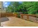 A wooden deck with railings offers an outdoor living space with lush greenery surrounding the backyard at 2817 Lincoln Dr, Decatur, GA 30033