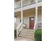 Close-up of the front door featuring a wood door, white railings, and meticulously maintained landscaping at 2817 Lincoln Dr, Decatur, GA 30033