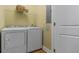 Well-lit laundry room with white washer and dryer, wire shelf and neutral wall color at 2817 Lincoln Dr, Decatur, GA 30033