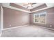 Spacious main bedroom features tray ceiling, carpet, and a window offering natural light at 3271 Pennington Dr, Stonecrest, GA 30038