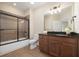 Well-lit bathroom featuring a shower-tub combination, dark granite countertops, and stylish dark wood cabinetry at 328 Brookhaven Walk, Johns Creek, GA 30097