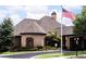 Stately brick clubhouse with decorative details, well-manicured landscaping, and an American flag at 328 Brookhaven Walk, Johns Creek, GA 30097