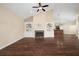 Spacious living room with a fireplace, built-in shelving, hardwood floors, and a ceiling fan at 328 Brookhaven Walk, Johns Creek, GA 30097