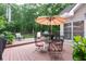 A charming back deck has a dining table, chairs, and umbrella for relaxing and entertaining at 3750 Cannonwolde Dr, Snellville, GA 30039