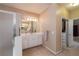 Bathroom with double sinks, shower and door leading to the walk-in closet at 3750 Cannonwolde Dr, Snellville, GA 30039