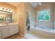 A bathroom features a white vanity, tub and stained glass window at 3750 Cannonwolde Dr, Snellville, GA 30039