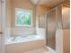 Bright bathroom features tub with tile surround and frameless glass shower doors at 3750 Cannonwolde Dr, Snellville, GA 30039