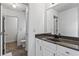 Bright bathroom featuring a white vanity, dark countertop, and a well-lit mirror at 6175 Beaver Crossing Dr, Cumming, GA 30040