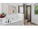 Bright bathroom with a soaking tub beneath a window and glass-enclosed shower stall at 6175 Beaver Crossing Dr, Cumming, GA 30040