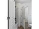 Bathroom with neutral finishes featuring a standard shower-tub and white door at 6175 Beaver Crossing Dr, Cumming, GA 30040
