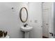 Neutral bathroom featuring a pedestal sink, towel rack and white door at 6175 Beaver Crossing Dr, Cumming, GA 30040