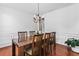 Light-filled dining room showcasing modern chandelier, white trim and wood flooring at 6175 Beaver Crossing Dr, Cumming, GA 30040