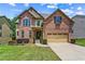Charming two-story brick home with manicured lawn and attached two car garage at 6175 Beaver Crossing Dr, Cumming, GA 30040