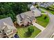 Aerial view of a charming brick home with manicured lawn and mature trees in a suburban neighborhood at 6175 Beaver Crossing Dr, Cumming, GA 30040