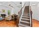 Cozy living room and staircase boasts hardwood floors, a fireplace, and coffered ceilings at 6175 Beaver Crossing Dr, Cumming, GA 30040