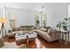 Bright living room featuring large windows, neutral decor, and stylish furnishings at 6175 Beaver Crossing Dr, Cumming, GA 30040