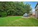 Lush backyard featuring a large grassy area and a covered outdoor grill at 1610 Kenilworth Se Ln, Conyers, GA 30013