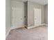 Carpeted bedroom with two white doors at 1610 Kenilworth Se Ln, Conyers, GA 30013