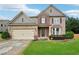 Charming two-story home featuring stone and brick accents, a two-car garage, and a well-manicured lawn at 1610 Kenilworth Se Ln, Conyers, GA 30013