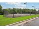 Community tennis court surrounded by a tall fence and lush greenery at 1610 Kenilworth Se Ln, Conyers, GA 30013