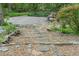 Stone steps leading to a gravel backyard featuring a picnic table at 1850 Winchester Trl, Brookhaven, GA 30341