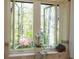 Bright bathroom with open windows offering serene nature views, a clawfoot tub and decorative tiling at 1850 Winchester Trl, Brookhaven, GA 30341