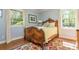 Cozy bedroom with wood floors, bright windows and a comfortable bed on a colorful decorative rug at 1850 Winchester Trl, Brookhaven, GA 30341