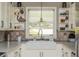 Bright kitchen boasts a farmhouse sink, open shelving with decorations, and a window offering a serene view at 1850 Winchester Trl, Brookhaven, GA 30341
