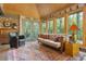 Inviting sunroom features wood ceiling, bright windows with outdoor view, and comfortable seating with colorful rug at 1850 Winchester Trl, Brookhaven, GA 30341