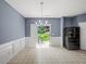 Bright dining area with a patio view, modern chandelier, and a sleek, black refrigerator at 2776 Snapfinger Mnr # 2776, Decatur, GA 30035