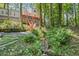 Lush backyard with a stream and a tiered deck, offering a serene and private outdoor space at 1279 Colony Pl, Marietta, GA 30068