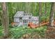 View of the exterior of a multi-story home nestled in a wooded lot with a wooden deck and stairs at 1279 Colony Pl, Marietta, GA 30068