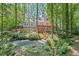 Gray home with wood decks overlooks a wooded backyard with a creek, fire pit, and natural landscaping at 1279 Colony Pl, Marietta, GA 30068