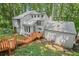 Exterior of a gray home with a wood staircase and a view of the surrounding green trees at 1279 Colony Pl, Marietta, GA 30068