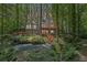 Gray home with wood decks overlooks a wooded backyard with a creek, fire pit, and natural landscaping at 1279 Colony Pl, Marietta, GA 30068