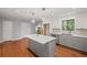 Bright, open kitchen with gray cabinets, stainless appliances, modern lighting, and hardwood floors at 1279 Colony Pl, Marietta, GA 30068