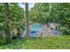 Community pool with lounge chairs, blue umbrellas, and a cabana surrounded by lush green trees at 1279 Colony Pl, Marietta, GA 30068
