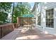 Enjoy outdoor living on this wooden deck featuring an umbrella, table, and mature trees for privacy at 3741 Cape York Trce, Alpharetta, GA 30022