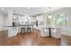 Open kitchen with white cabinets, stainless steel appliances, and an adjacent dining area with large windows at 3741 Cape York Trce, Alpharetta, GA 30022