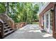 Concrete patio with steps and access to the house, featuring white trimmed windows and a brick wall at 3741 Cape York Trce, Alpharetta, GA 30022
