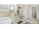 Well-lit primary bathroom featuring a glass shower, soaking tub, and neutral tile at 610 Brickstone Ct, Covington, GA 30016