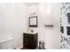 Bathroom featuring a dark wood vanity, decorative mirror, stainless steel trash can, and a toilet at 610 Brickstone Ct, Covington, GA 30016