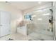 Well-lit primary bath with soaking tub, glass shower, and tiled walls at 610 Brickstone Ct, Covington, GA 30016