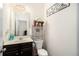 Cozy half bathroom with a dark vanity, decorative mirror, and stylish accessories at 610 Brickstone Ct, Covington, GA 30016