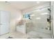 Bright bathroom featuring a glass shower enclosure and separate soaking tub beneath a window at 610 Brickstone Ct, Covington, GA 30016