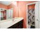Bright bathroom featuring an extensive vanity with dark wood cabinets and an adjacent shower at 610 Brickstone Ct, Covington, GA 30016