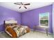 Bedroom featuring purple walls, carpet floors, window and modern light fixture at 610 Brickstone Ct, Covington, GA 30016