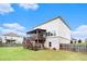 Spacious backyard with patio, wooden deck, and partially bricked house exterior under a blue sky at 610 Brickstone Ct, Covington, GA 30016