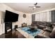 Spacious living room featuring a fireplace, plush leather sectional, and modern ceiling fan at 610 Brickstone Ct, Covington, GA 30016