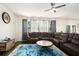 Spacious living room features large leather couch, ceiling fan, and natural lighting at 610 Brickstone Ct, Covington, GA 30016